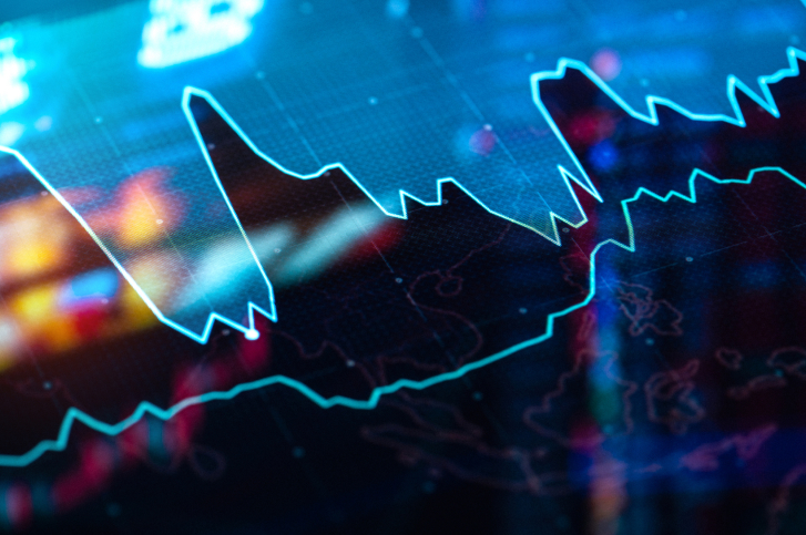 A imagem mostra um gráfico de linha azul brilhante sobre um fundo escuro e desfocado, sugerindo um tema de investimentos ou dados financeiros, possivelmente relacionados a criptomoedas, devido ao estilo digital e futurista. O gráfico exibe uma linha única que flutua significativamente, com picos e vales acentuados, ilustrando claramente a volatilidade. A linha é renderizada em um tom de azul elétrico ou ciano, que se destaca fortemente contra o fundo predominantemente preto com sutis tons de roxo e vermelho borrados em algumas áreas. A profundidade de campo é rasa, focando a atenção na linha do gráfico, enquanto o fundo parece ser um display digital com outros padrões abstratos e pontos luminosos que remetem a um mapa ou circuito eletrônico, mas estão suficientemente desfocados para não distrair. A iluminação é dramática, com o brilho da linha contrastando com as áreas mais escuras. No geral, a imagem evoca uma sensação de tecnologia, análise de dados e o dinamismo do mercado financeiro, com a volatilidade sendo o tema central visualmente representado pelo movimento errático da linha.